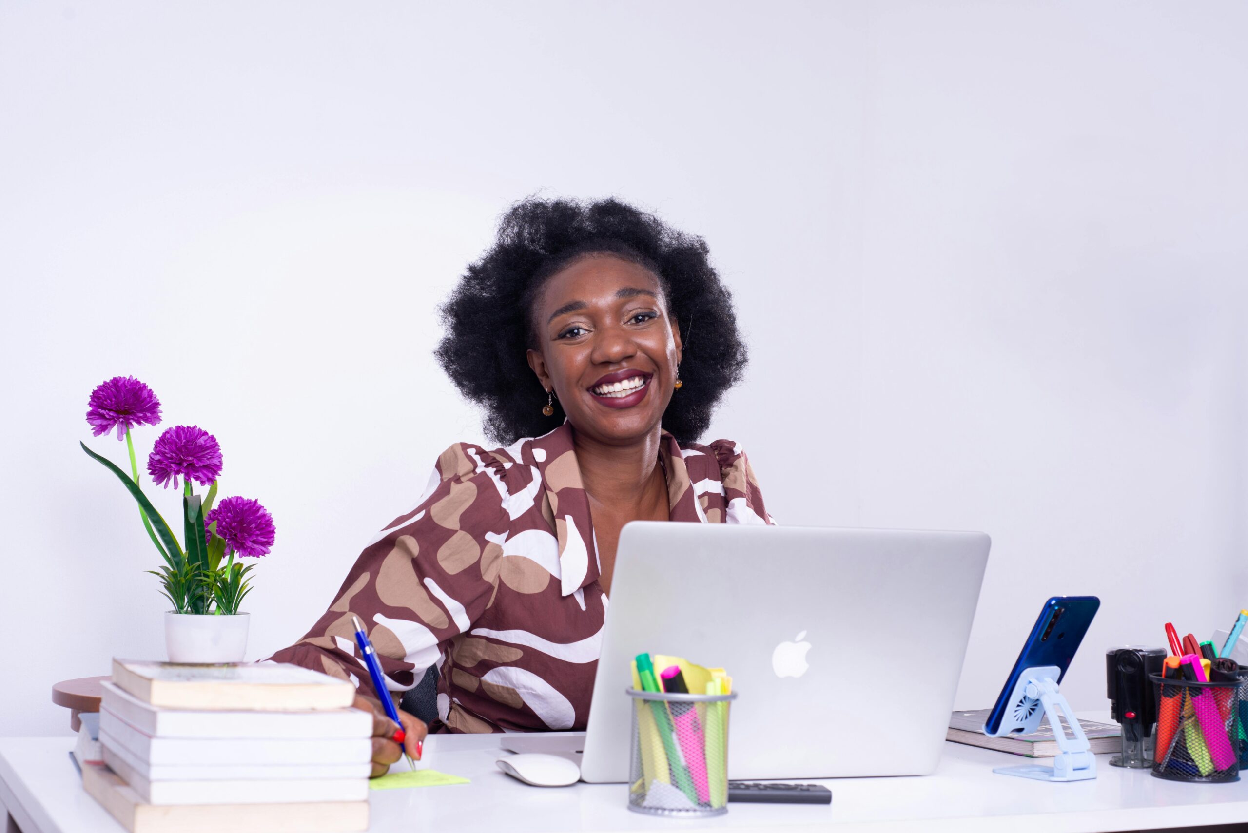 A cheerful African businesswoman working at her desk in Kinshasa, showcasing a lively professional workspace.